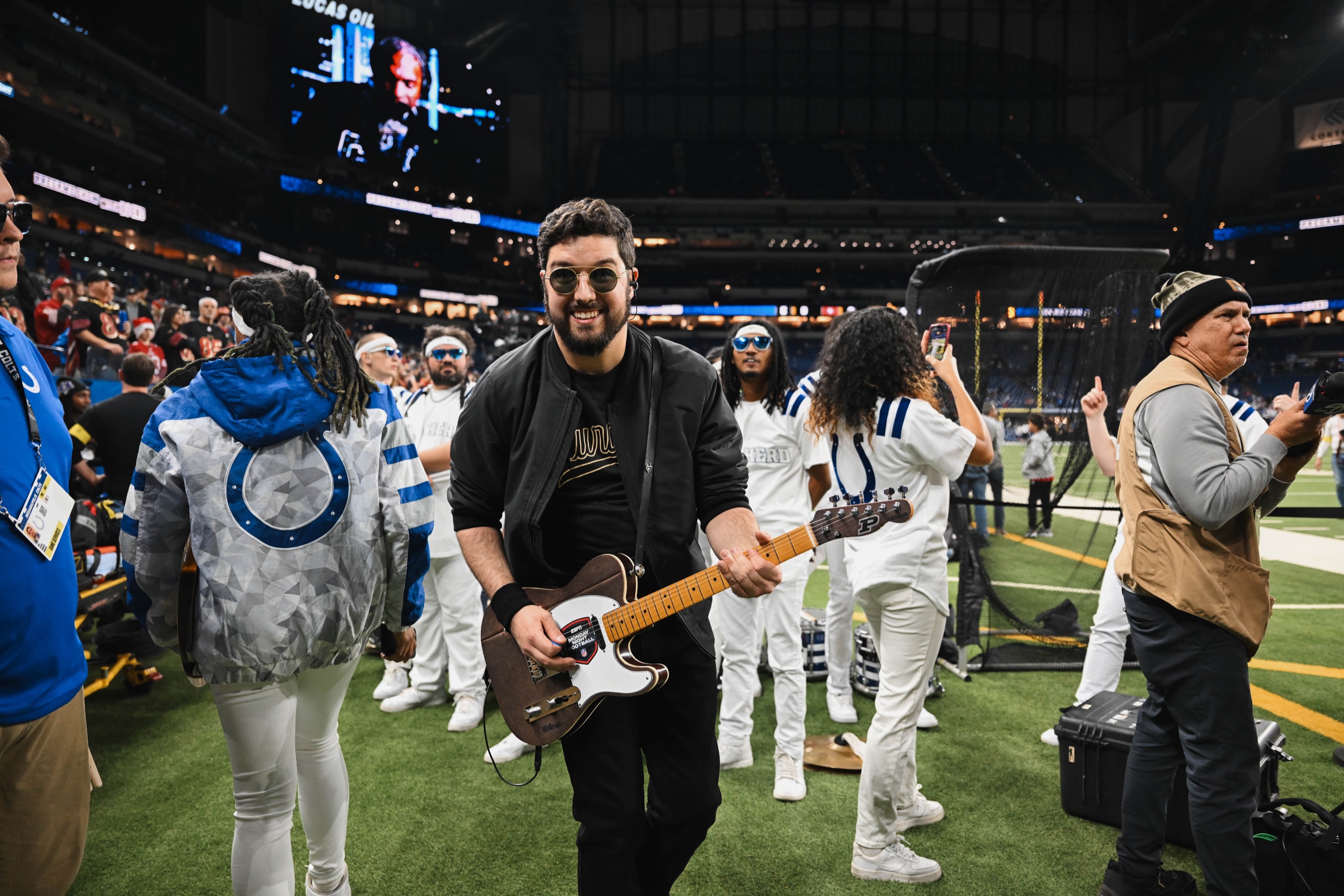 Noah Scott holding a guitar on the field during Monday Night Football