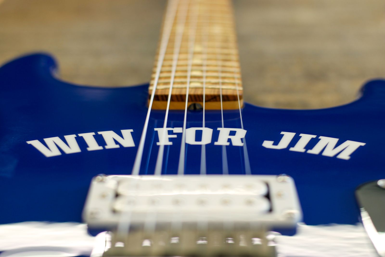 The Win for Jim guitar, Colts blue with WIN FOR JIM in white letters under the strings